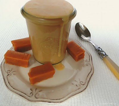 Toffee-Karamellsoße in einem Glas mit Toffee-Bonbons im Vordergrund.