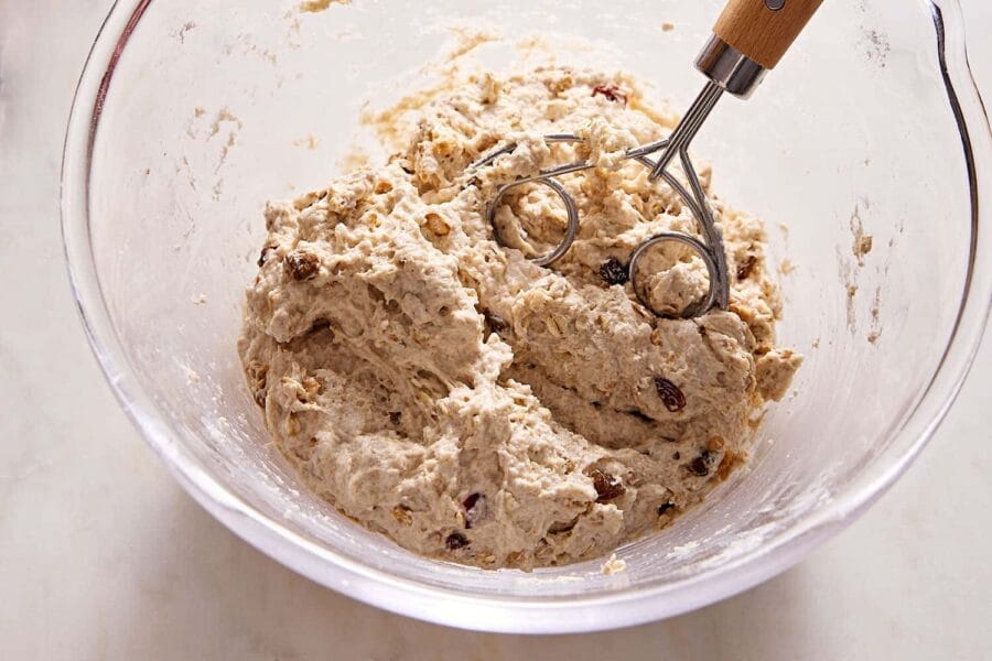 Teig für Müslibrötchen mit Quark, der in einer Schüssel gemischt wird.