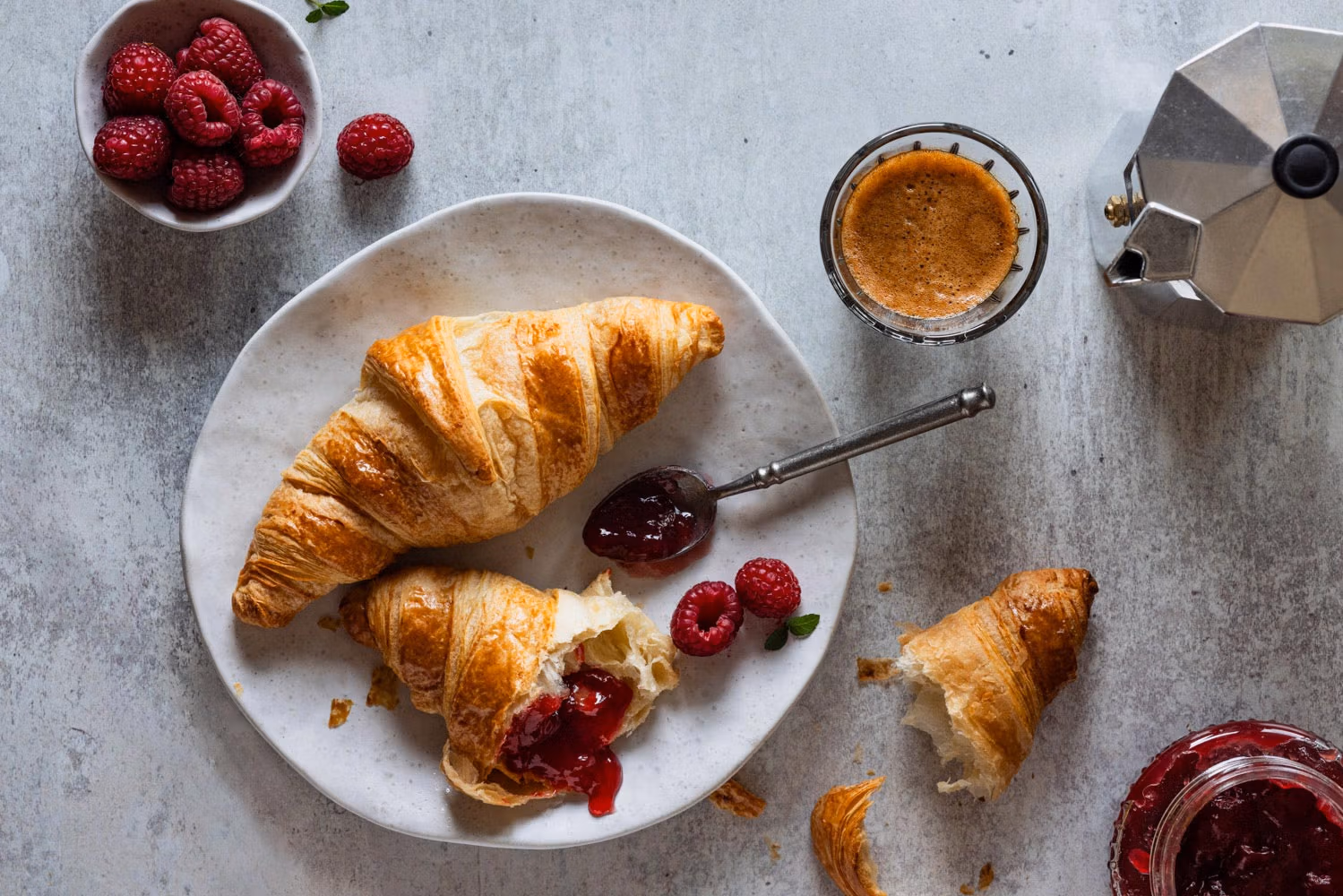 Croissants mit Himbeermarmelade und Kaffee.
