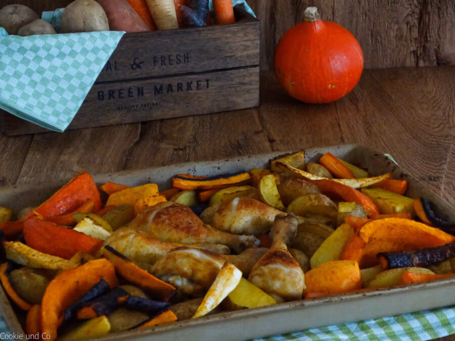 Herbstliches Ofengemüse mit Hähnchenkeulen.
