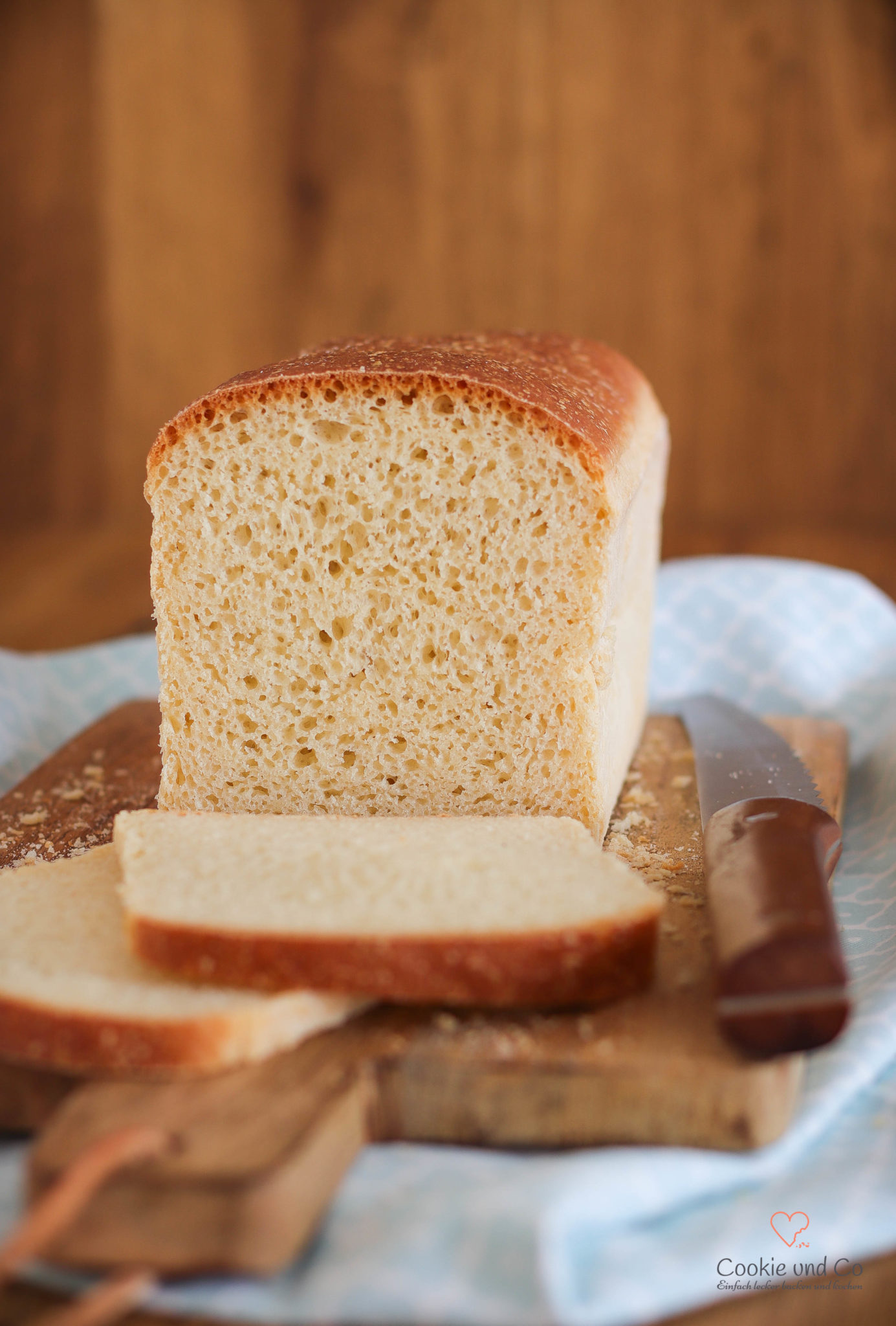 Einfaches Dinkel-Weißbrot, aufgeschnitten auf einem Holzbrett.