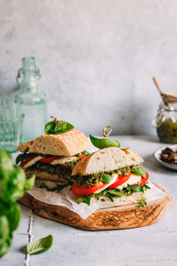 Caprese Sandwich aus Ciabatta, Pesto Verde, Tomaten und Mozzarella.