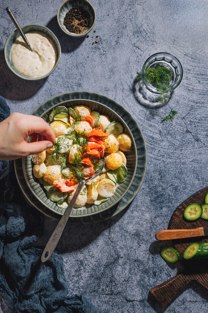 Kartoffelsalat mit Gurke ohne Mayonnaise, garniert mit Dill und Stremellachs.