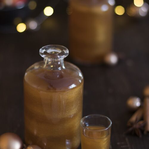 Bratapfel-Likör mit Goldglitzer in einem weihnachtlichem Setting.