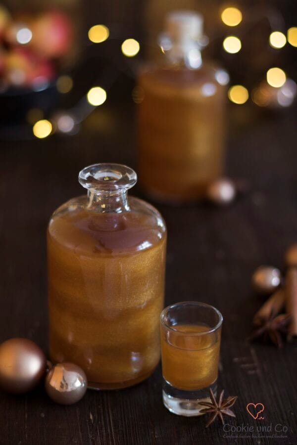 Bratapfel-Likör mit Goldglitzer in einem weihnachtlichem Setting.