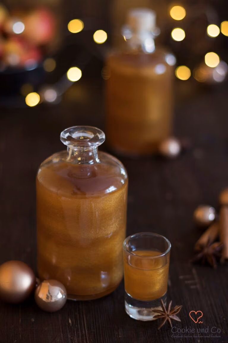 Bratapfel-Likör mit Goldglitzer in einem weihnachtlichem Setting.