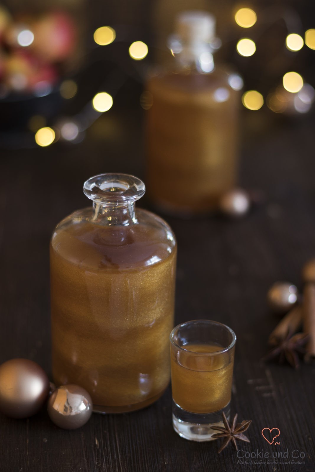 Bratapfel-Likör mit Goldglitzer in einem weihnachtlichem Setting.