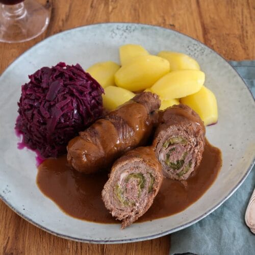 Klassische Rinderrouladen aus dem Ofen mit Soße, mit Rotkohl und Salzkartoffeln.