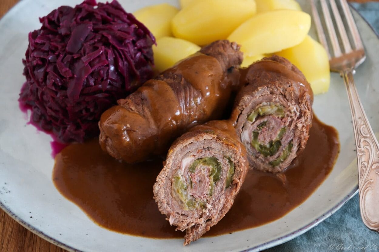Klassische Rinderrouladen aus dem Ofen mit Soße, mit Rotkohl und Salzkartoffeln.