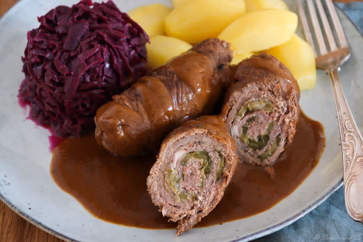 Klassische Rinderrouladen aus dem Ofen mit Soße, mit Rotkohl und Salzkartoffeln.