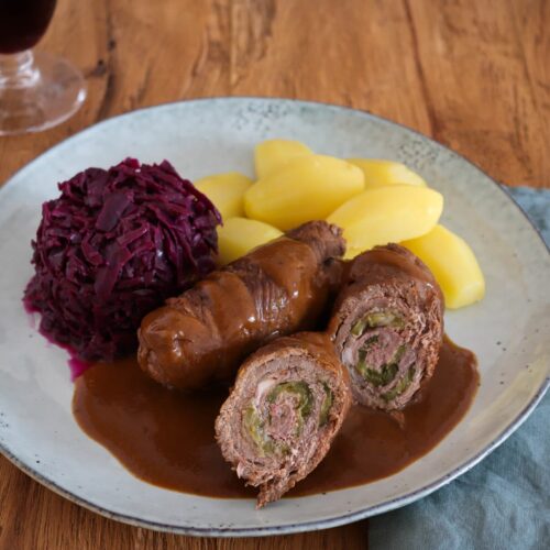 Klassische Rinderrouladen aus dem Ofen mit Soße, mit Rotkohl und Salzkartoffeln.