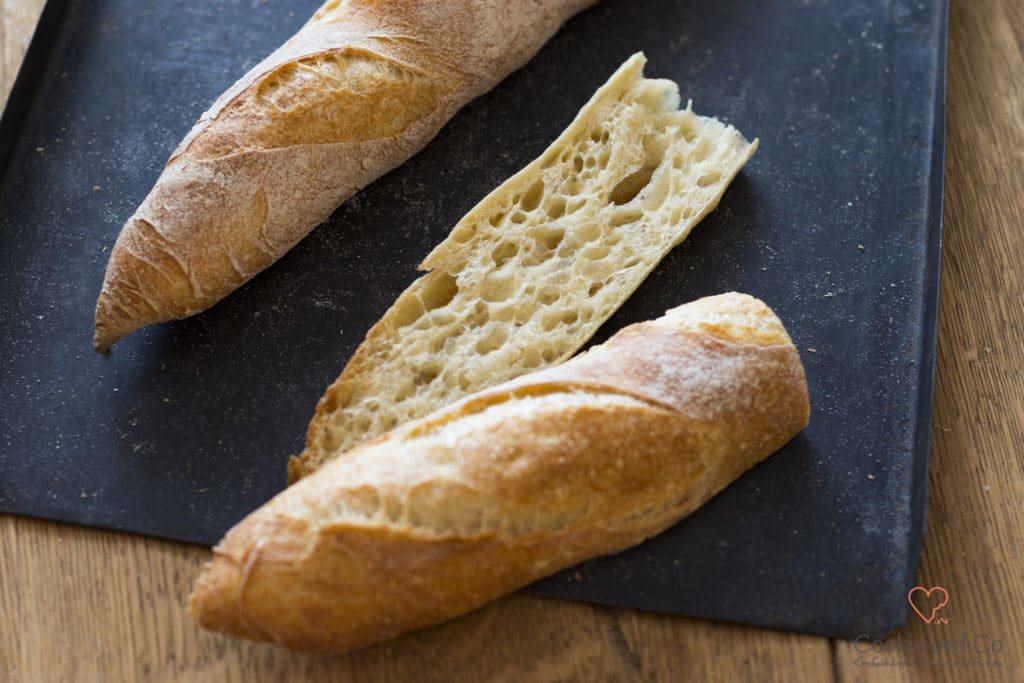 Baguette aufgeschnitten auf einem alten Backblech.