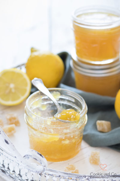 Orangen-Zitronen-Gelee mit frischen Zitronen und kandiertem Ingwer auf einem Tablett.