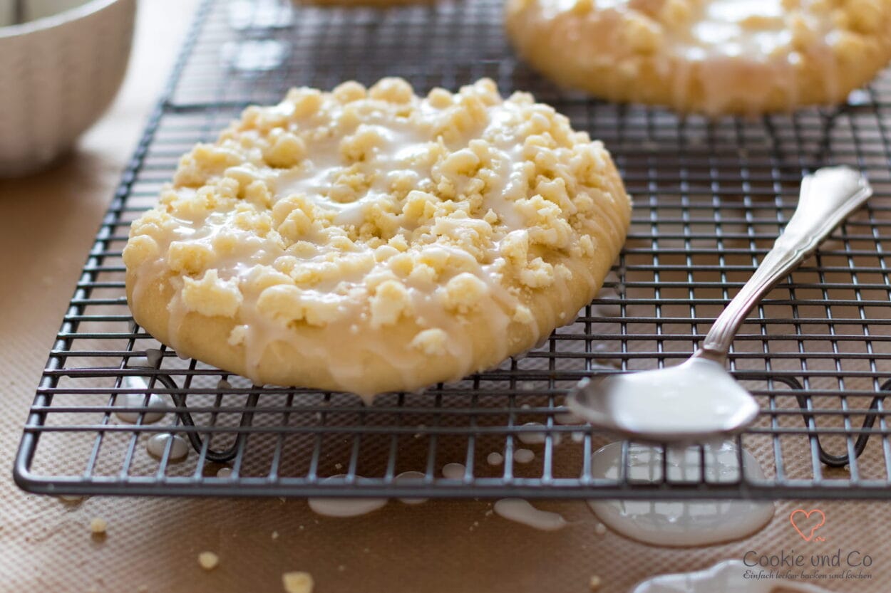 Klassische Streuseltaler aus fluffigem Hefeteig mit dicken Streuseln und Zuckerguss.