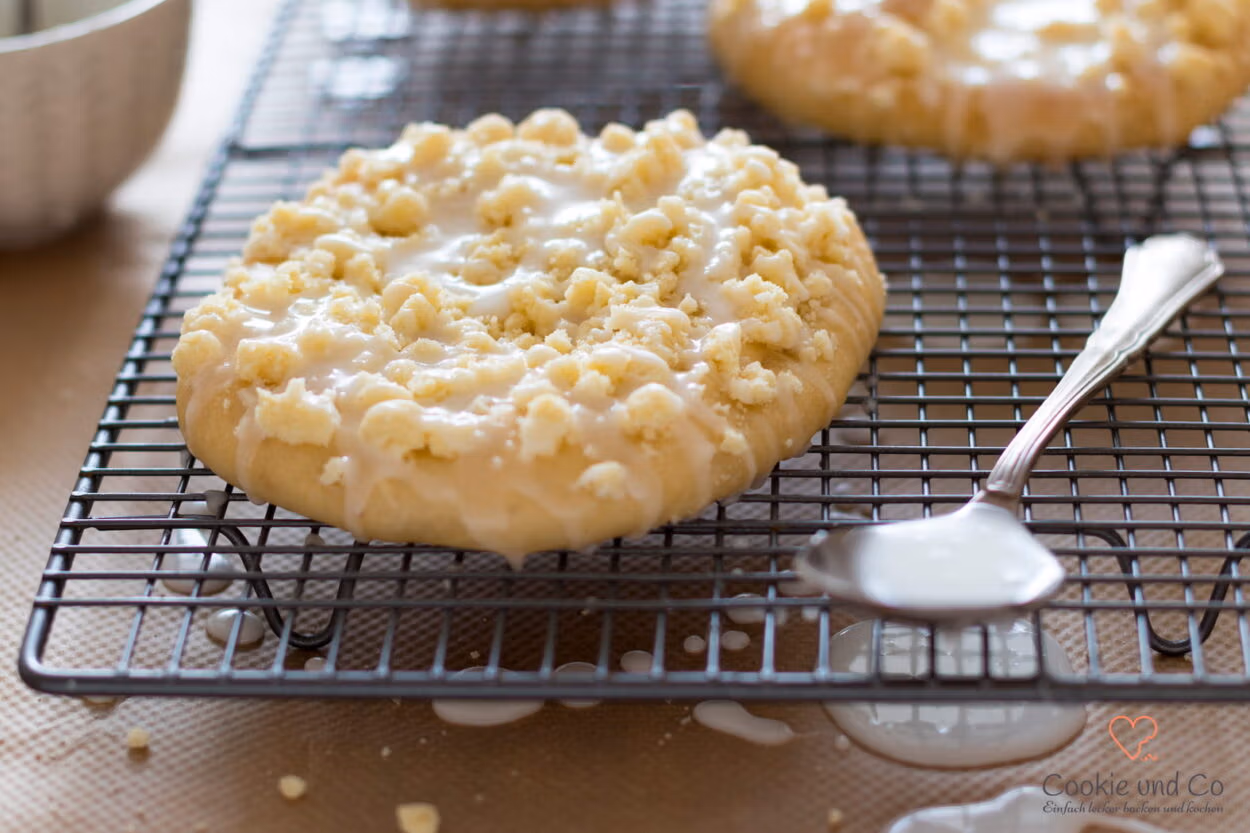 Klassische Streuseltaler aus fluffigem Hefeteig mit dicken Streuseln und Zuckerguss.