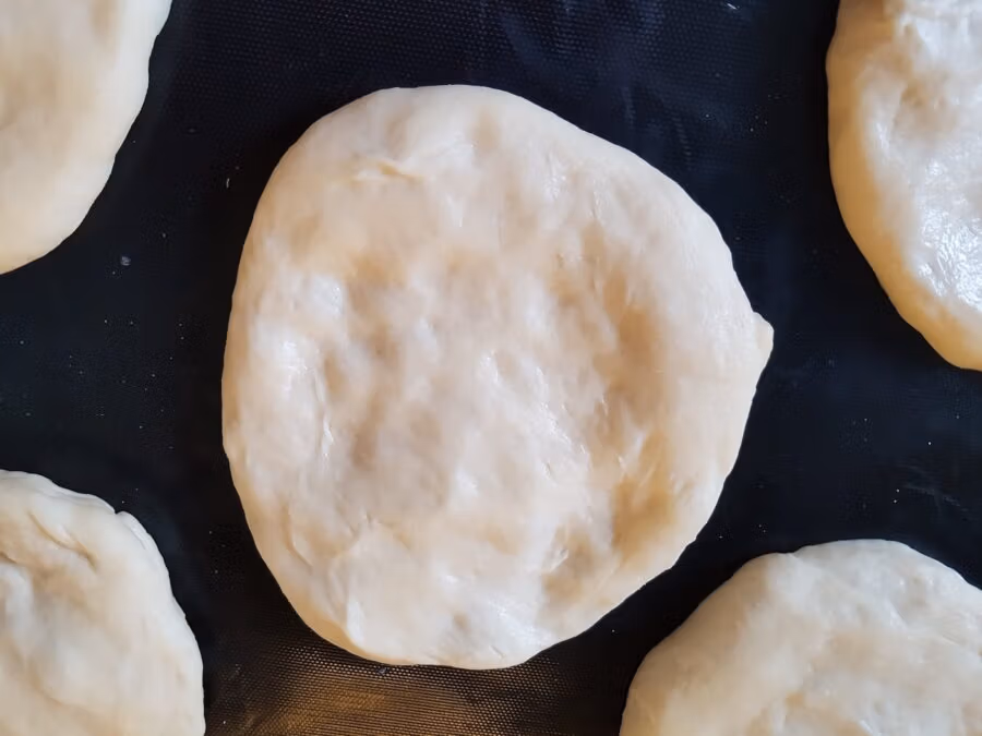 Geformter Hefeteig für Streuseltaler auf einem Backblech.