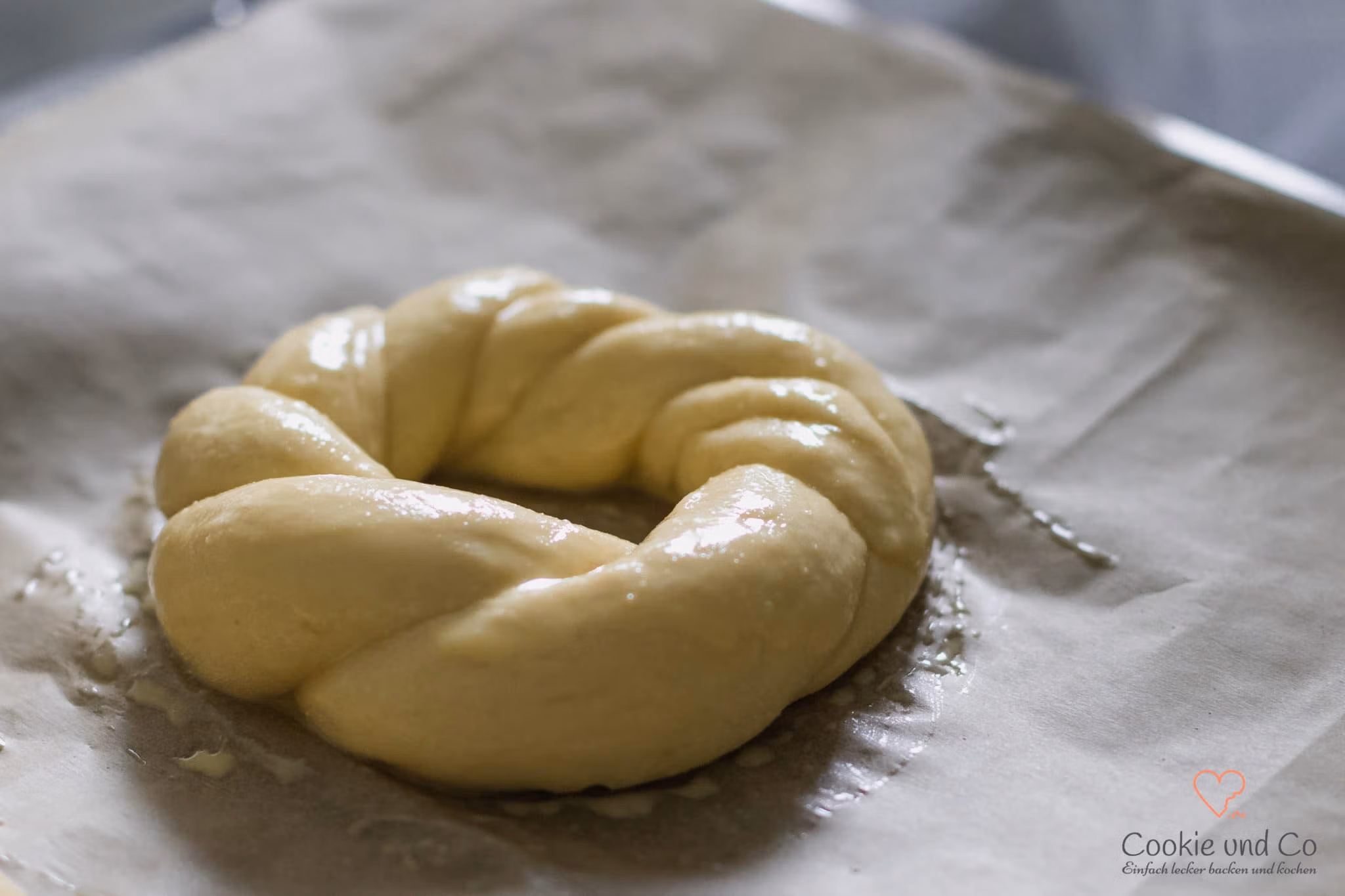 Geformter Hefeteig für Osterkränze auf einem Backblech.