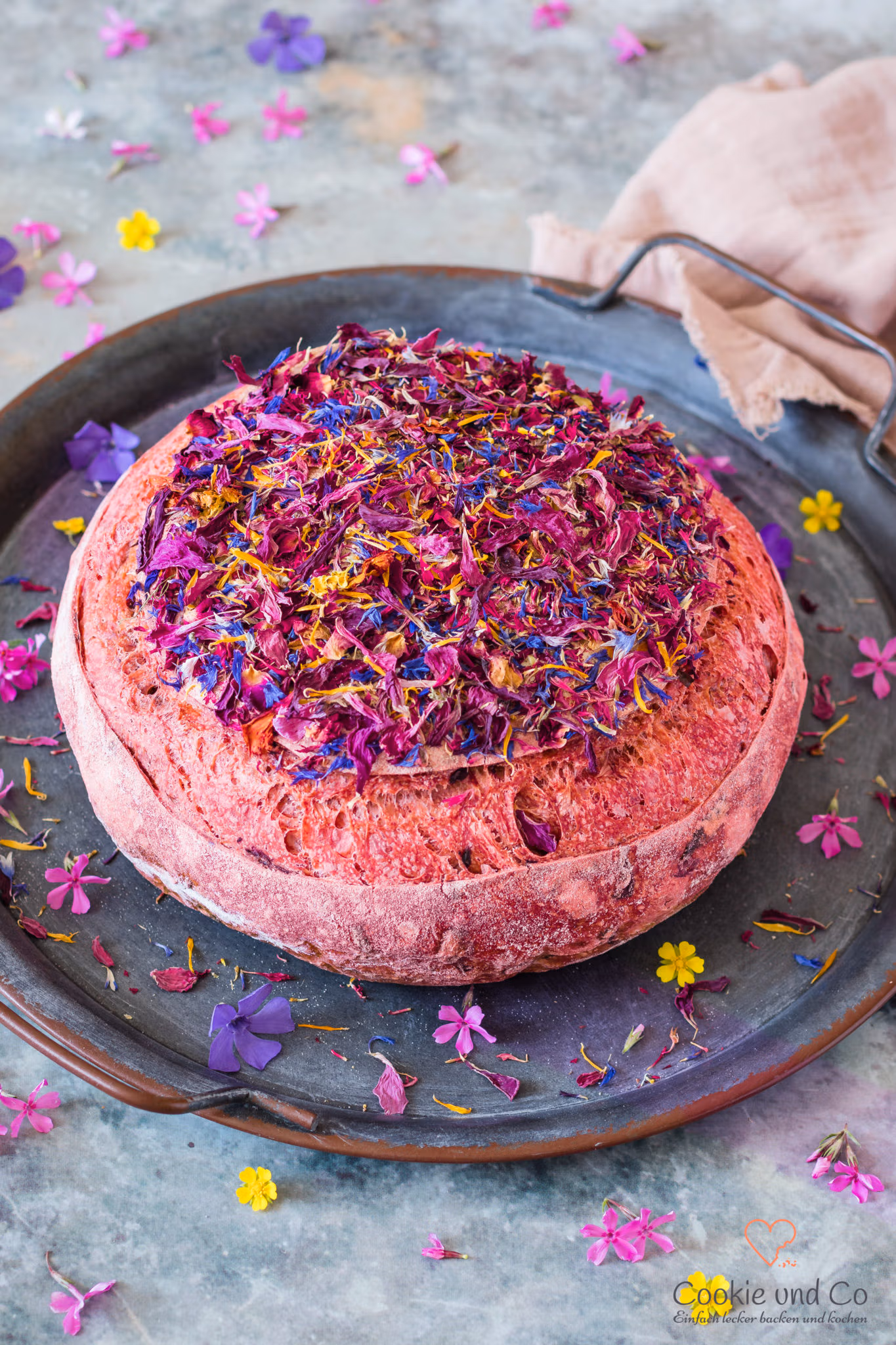 Pain de fleur, ein rosafarbene Weizenbrot mit Rote beete Saft und einem Topping aus getrockneten bunten Blüten.