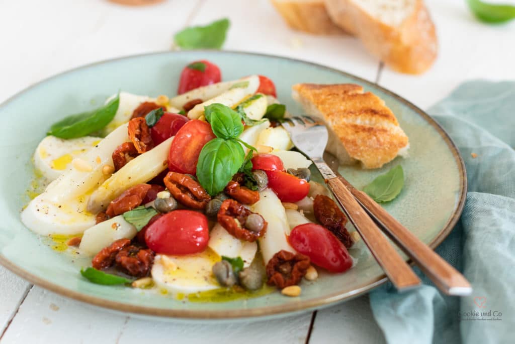 Spargelsalat mit Tomaten und Mozzarella auf einem Teller