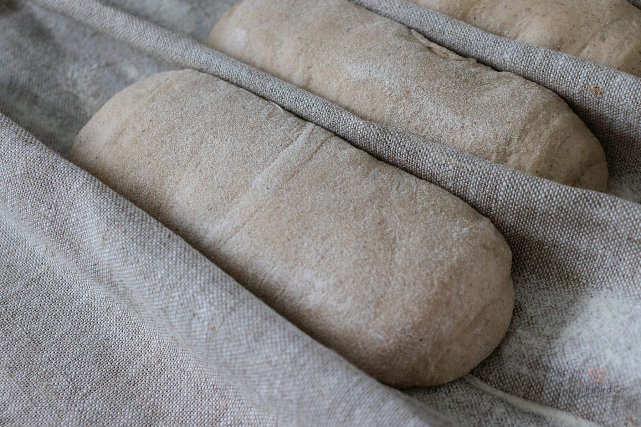 Vorgeformte Baguette-Teiglinge (Preshape) bei der Zwischengare im Bäckerleinen.