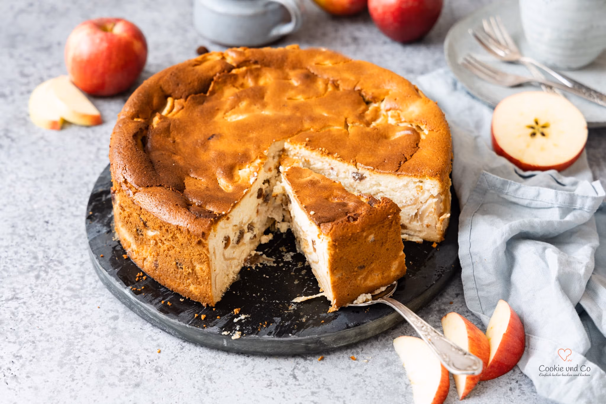 Saftiger Apfel-Grieß-Kuchen mit Äpfeln und einer Tasse Kaffee im Hintergrund.