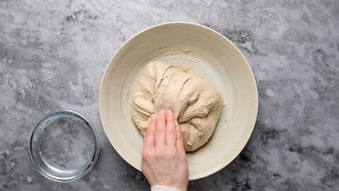 Dehnen und Falten während der Stockgare beim Teig für Mischbrot mit Sauerteig.