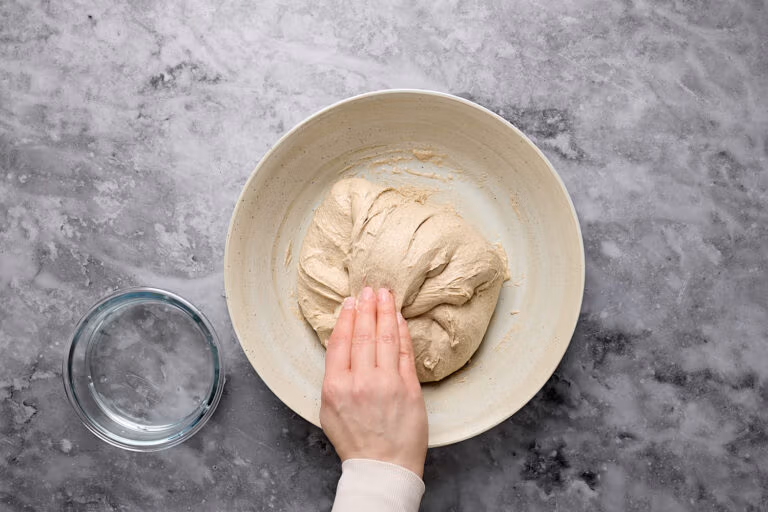 Dehnen und Falten während der Stockgare beim Teig für Mischbrot mit Sauerteig.