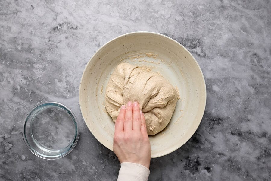 Dehnen und Falten während der Stockgare beim Teig für Mischbrot mit Sauerteig.