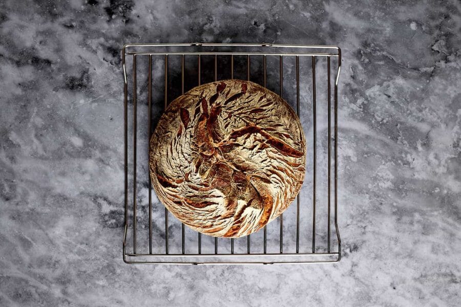 Frisch gebackenes Mischbrot mit Sauerteig nach dem backen auf einem Rost zum Auskühlen.