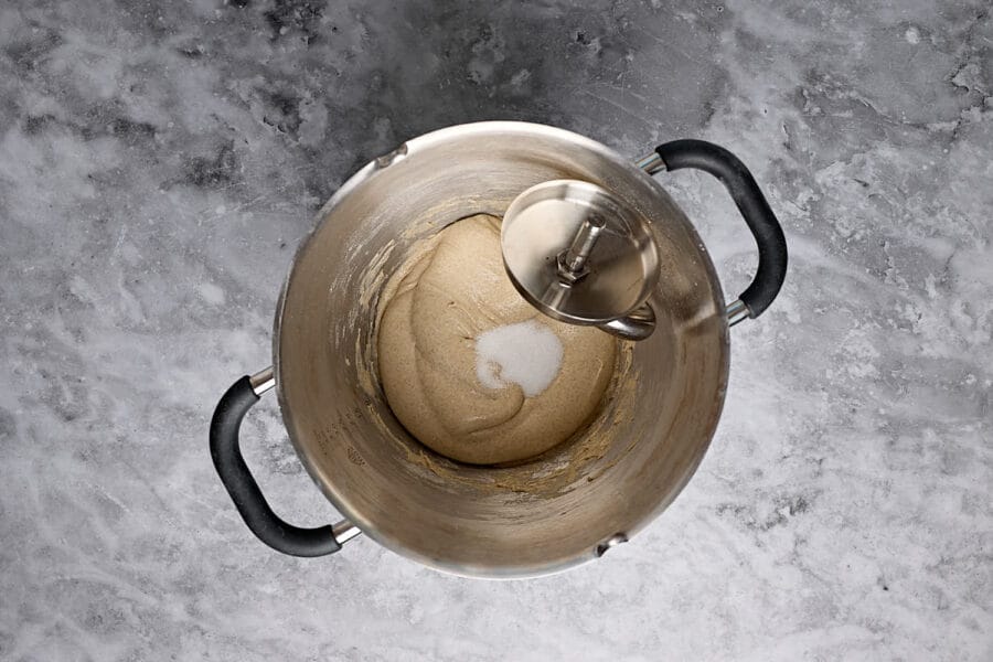 Gemischter Hauptteig für Mischbrot mit Sauerteig mit Salz in einer Knetschüssel vor dem Auskneten.
