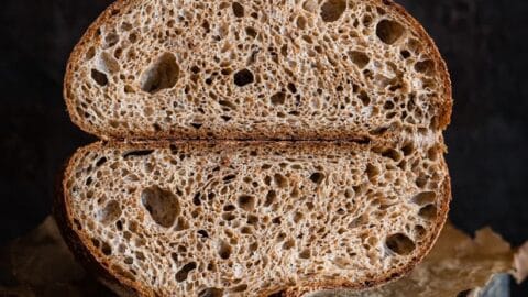 Vollkornbrot mit Sauerteig und lockerer Krume auf einem Holzbrett.