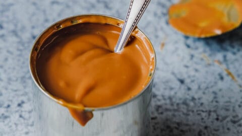 Milchkaramell oder Dulce de leche in eine Dose mit einem Löffel.