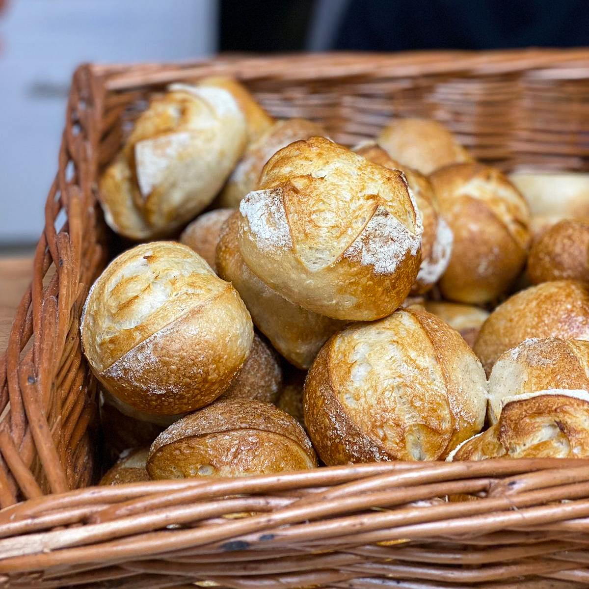 Frisch gebackene Brötchen in einem großen Weidenkorb.