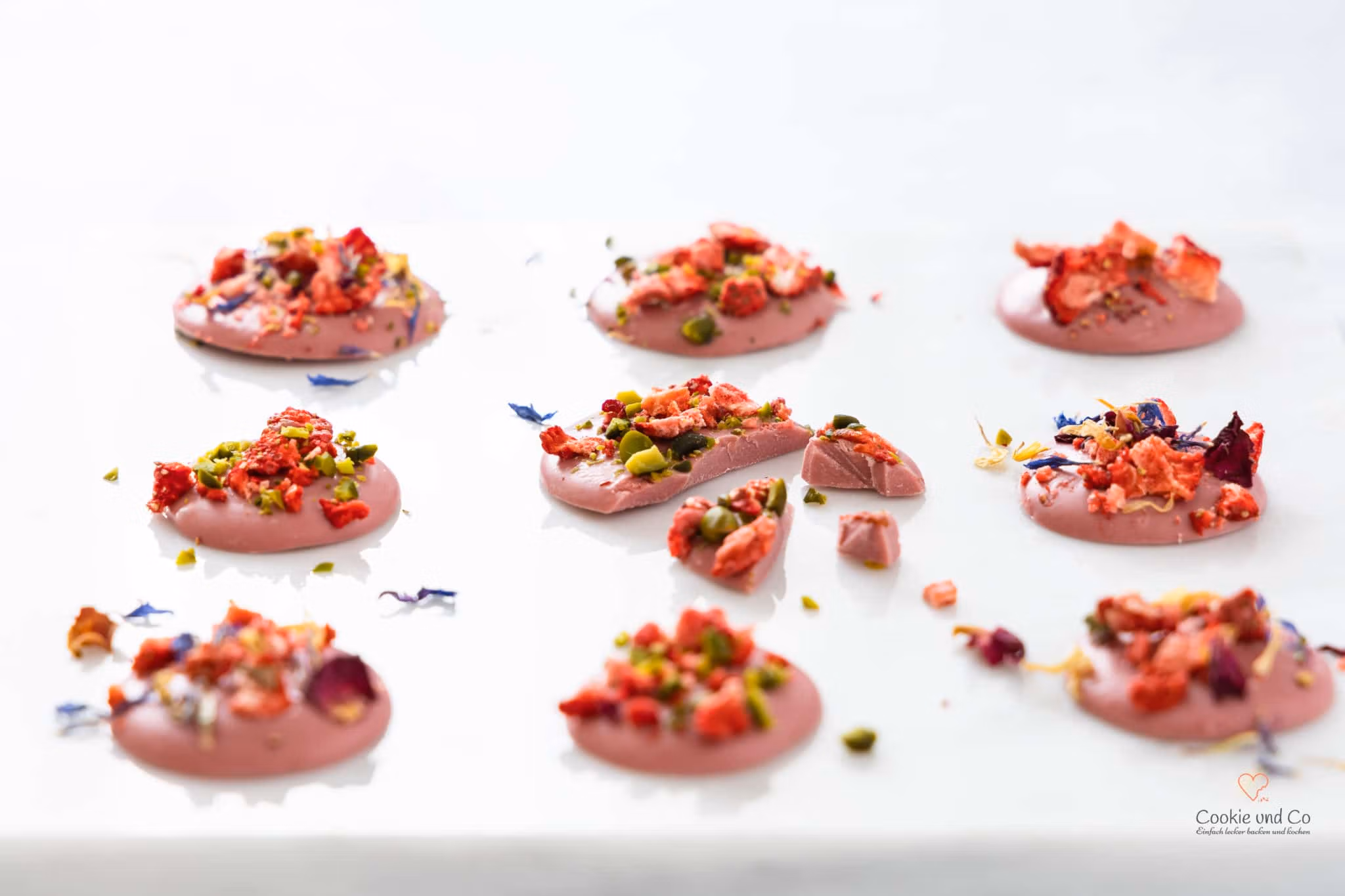 Ruby Chocolate Bites – ein Snack aus rosafarbener Ruby Schokolade, getoppt mit getrockneten Früchten, Pistazien und Blüten.