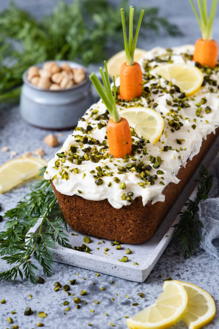 Rüblikuchen oder Carrot Cake mit Frisckäse-Frosting und Pistazien Topping.