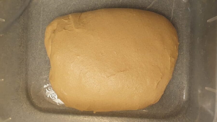 Gefalteter Teig für eine Weizenvollkornkruste in einer geölten Teigwanne.