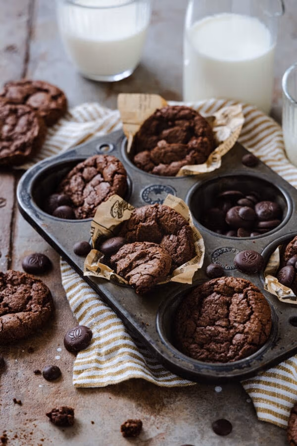 Brotwnie-Cookies in einer alten Backform mit Schokoladen Stücken und Milchgläsern im Hintergrund.