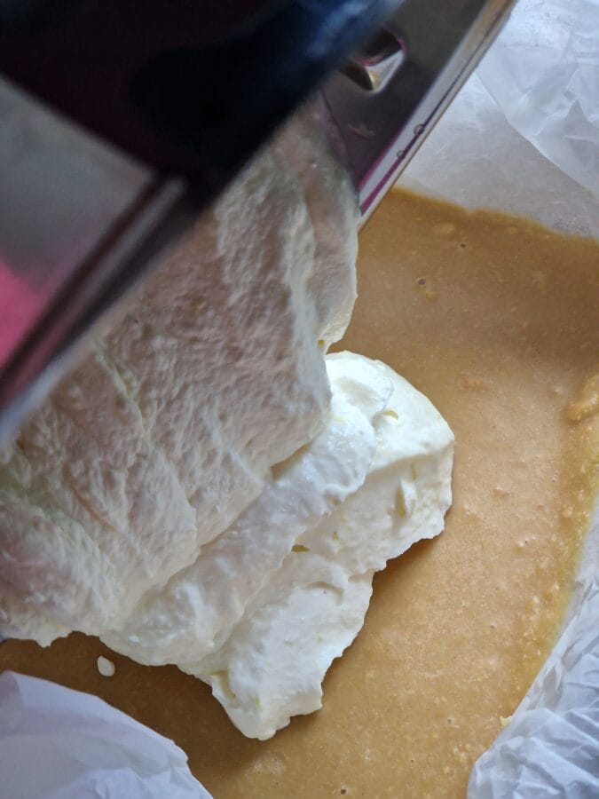 Cheesecakemasse, die auf den Keksboden gegeben wird.