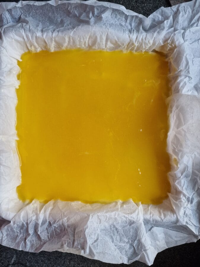 Fertiger Lemon Cheescake in der Kuchenform mit Backpapier vor dem Kaltstellen.