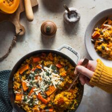 Kürbisrisotto aus dem Ofen mit Parmesankäse, Kürbiskernen und Thymian.