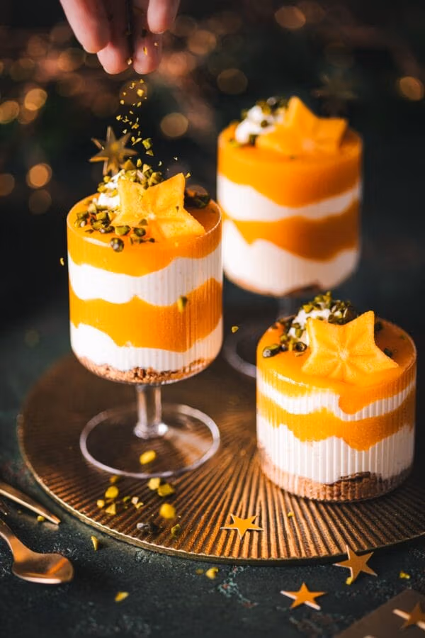 Weihnachtliches Kaki-Schichtdessert mit Joghurt-Creme und Kaki-Soße getoppt mit Pistazien. 