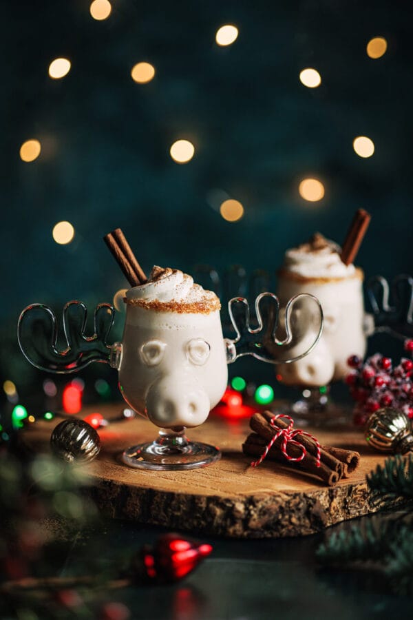 Alkoholfreier Eierpunsch in einer Elchtasse mit Sahnehaube und Zimtstange in einem weihnachtlichen Setting. 