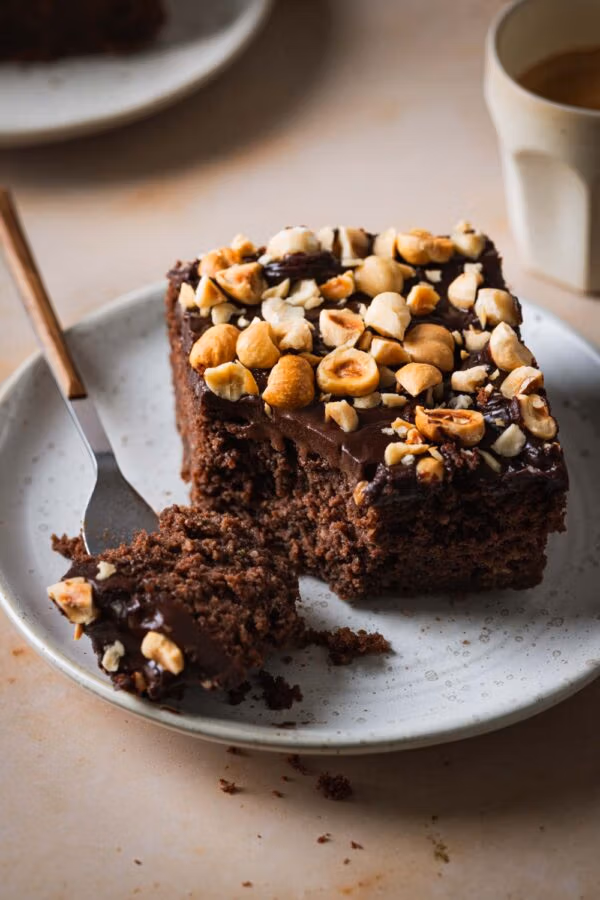 Saftiger Schoko-Zucchinikuchen mit Schokoglasur und Haselnüssen.