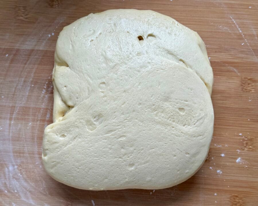Reifer Teig für Brioche Buns auf der leicht bemehlten Arbeitsfläche.