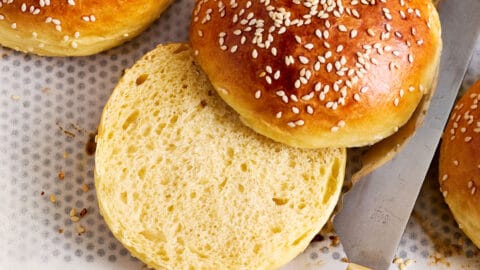 Aufgeschnittener Brioche Bun auf dem Backblech mit lockerer, weicher Krume.