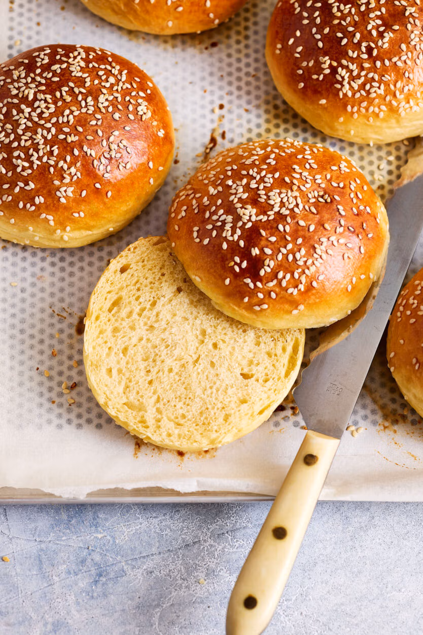 Aufgeschnittener Brioche Bun auf dem Backblech mit lockerer, weicher Krume.