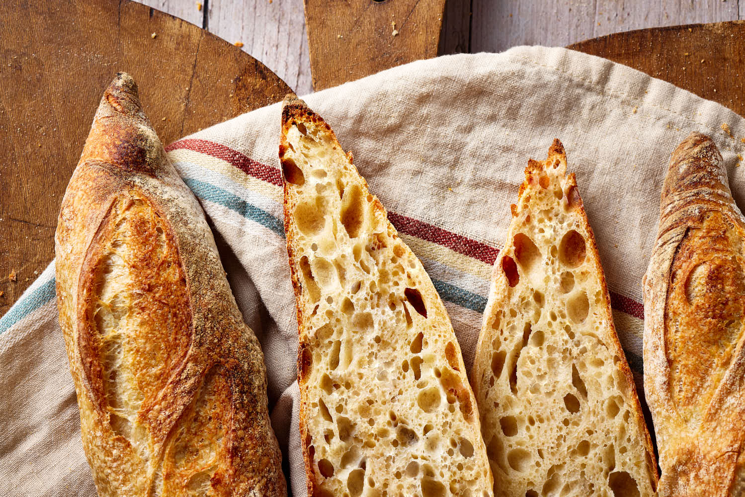 Sauerteig Baguette, aufgeschnitten auf einem rustikalen Holzbrett.