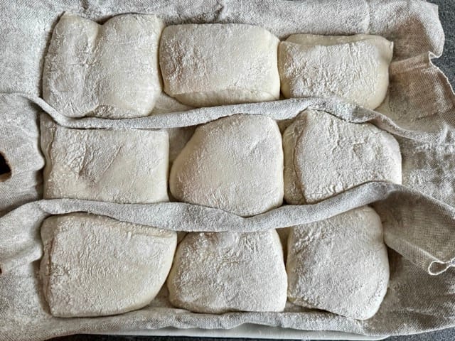 Abgestochene Brötchen-Teiglinge im Bäckerleinen während er Stückgare.