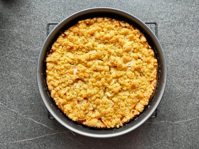 Apfelkuchen mit Quark und Streusel auf einem Kuchengitter beim Auskühlen.