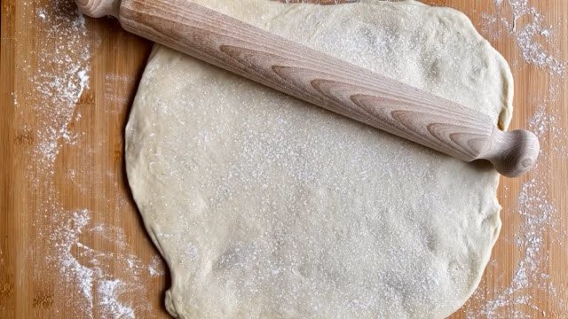 Hefeteig für Apfeltaschen ausrollen.